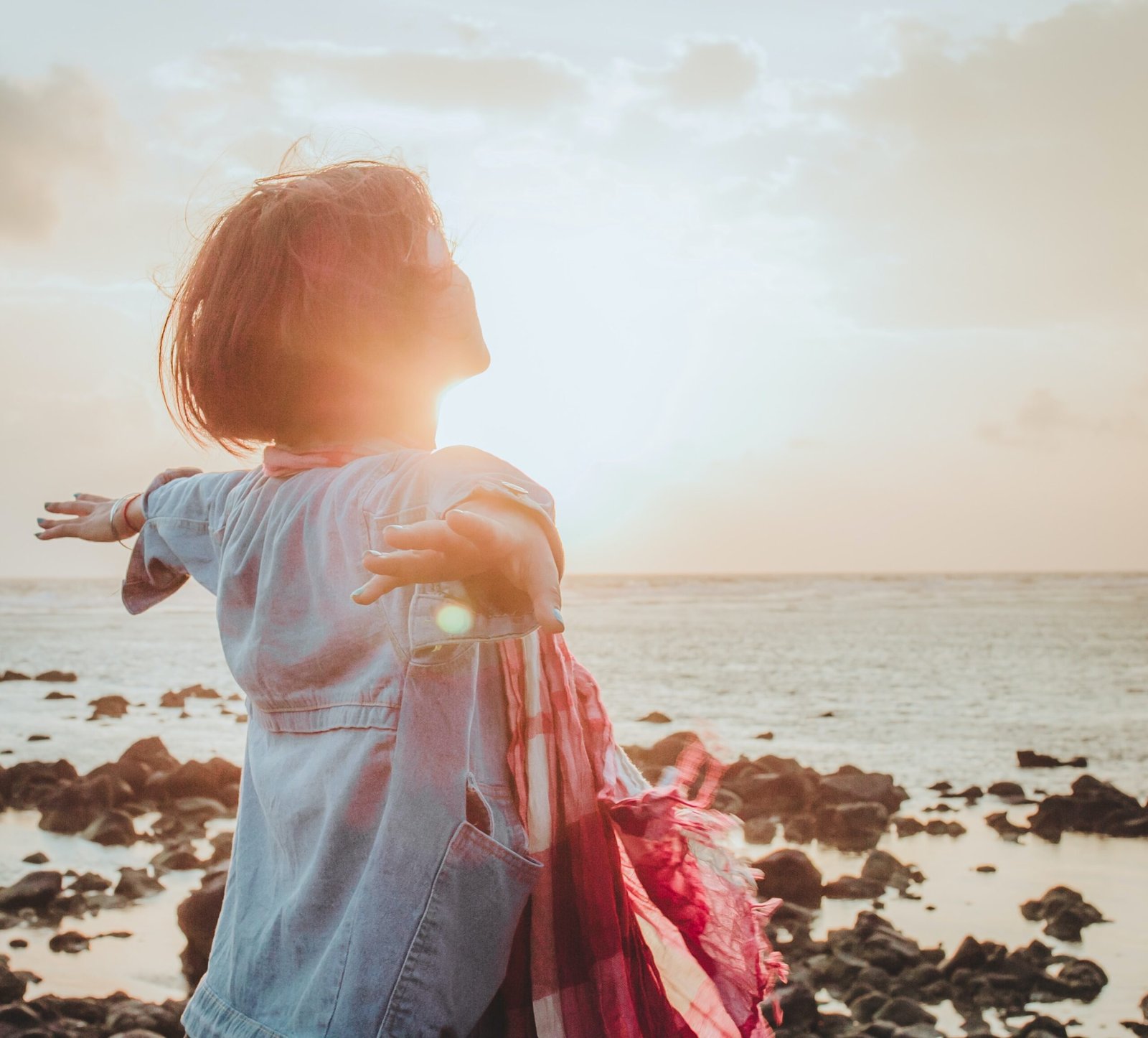 femme de dos, le visage tourné vers le soleil les bras écartés
au milieu un bouton indiquant coaching de vie